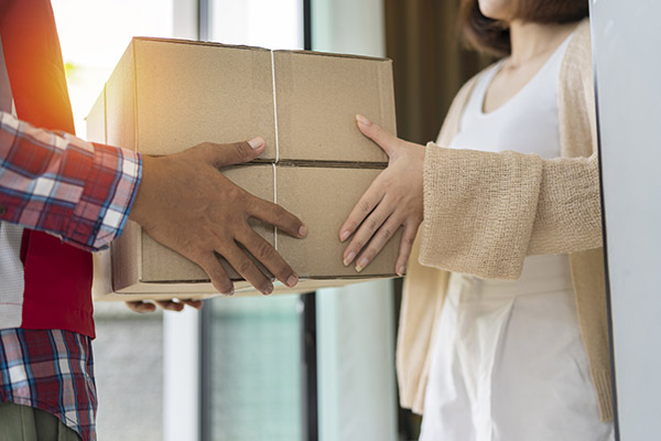 une femme et un homme qui tienne en leurs mains un colis