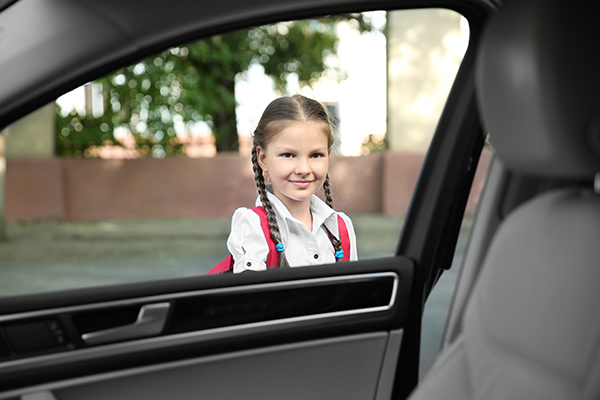 une petite fille avec des nattes qui ouvre la portière d'une voiture taxi